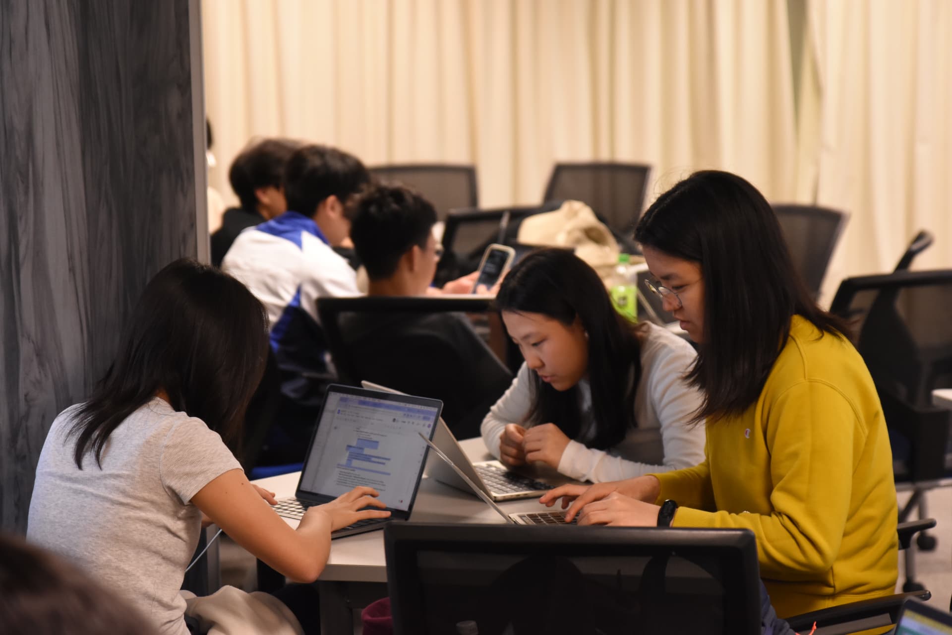 Students building a project together at a hackathon