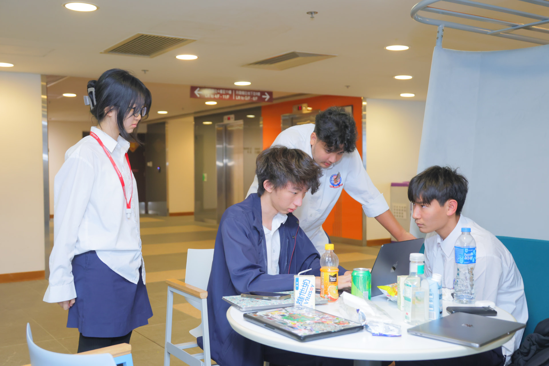 A student team collaborating around a laptop